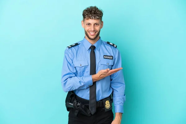 Young police blonde man isolated white on blue background presenting an idea while looking smiling towards