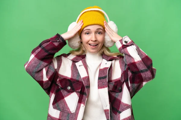 Young  English woman wearing winter muffs over isolated background with surprise expression