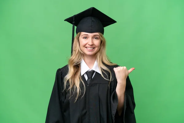 Young university English graduate woman over isolated background pointing to the side to present a product