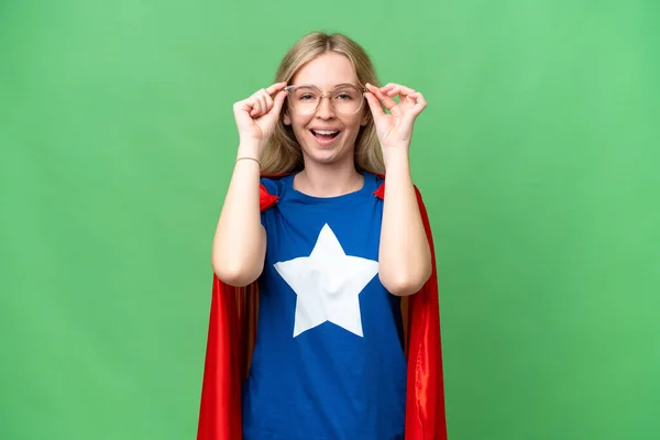 Super Hero English woman over isolated background with glasses and surprised