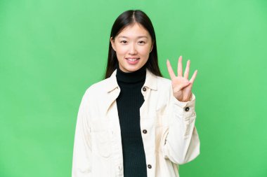 Young Asian woman over isolated chroma key background happy and counting four with fingers