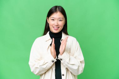 Young Asian woman over isolated chroma key background applauding after presentation in a conference