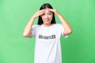 Young volunteer woman over isolated chroma key background with surprise expression