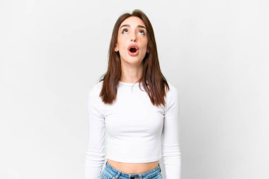 Young caucasian woman over isolated white background looking up and with surprised expression