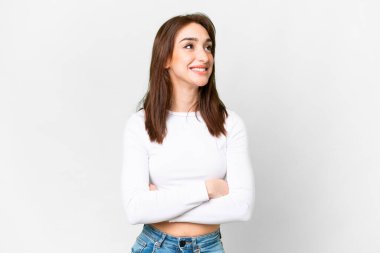 Young caucasian woman over isolated white background looking up while smiling