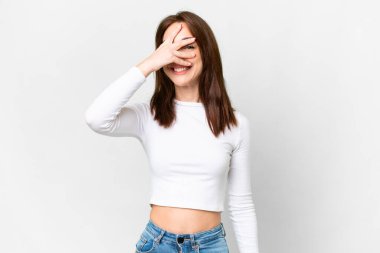 İzole edilmiş beyaz arka planda genç beyaz bir kadın. Gözleri kapalı ve gülümsüyor.