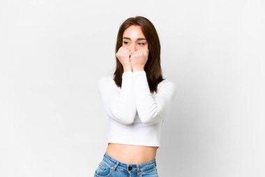 Young caucasian woman over isolated white background nervous and scared putting hands to mouth