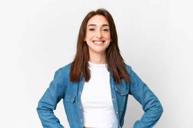 Young caucasian woman over isolated white background posing with arms at hip and smiling