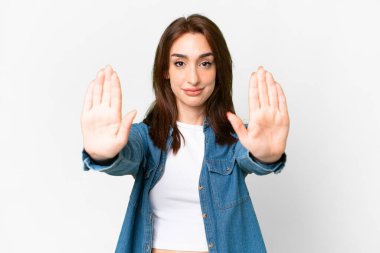 Young caucasian woman over isolated white background making stop gesture and disappointed