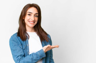 İzole edilmiş beyaz arka planda genç beyaz kadın gülümserken bir fikir sunuyor.