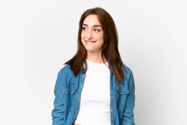 Young caucasian woman over isolated white background having doubts while looking up