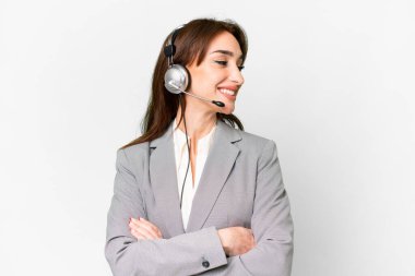 Telemarketer caucasian woman working with a headset over isolated white background happy and smiling