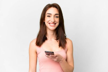 Young caucasian woman over isolated white background using mobile phone