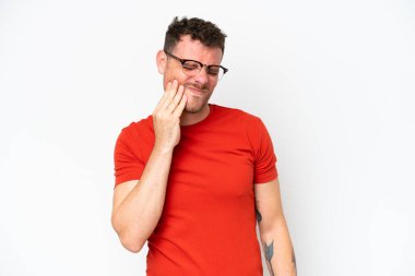 Beyaz arka planda diş ağrısı çeken beyaz tenli yakışıklı bir adam.