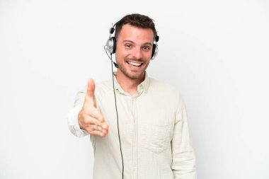 Beyaz arka planda izole edilmiş bir kulaklıkla çalışan beyaz pazarlamacı beyaz adam iyi bir anlaşma için el sıkışıyor.