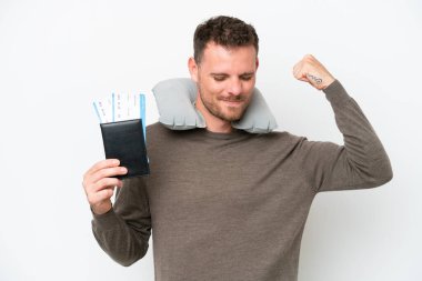 Young caucasian man holding a passport isolated on white background doing strong gesture
