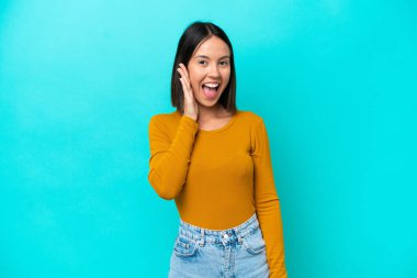 Yüzünde şok ifadesi olan mavi arka planda izole edilmiş beyaz bir kadın.