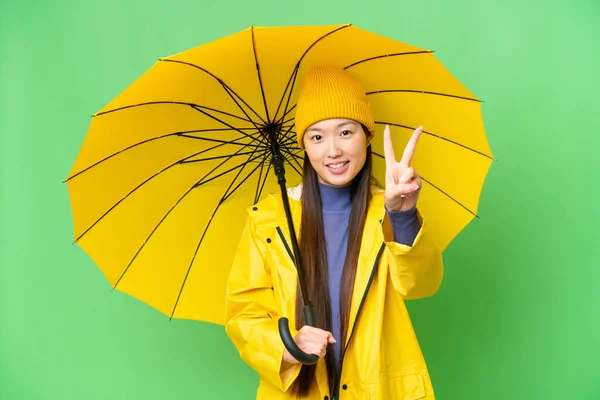 Jonge Aziatische Vrouw Met Regenbestendige Jas Paraplu Geïsoleerde Chroma Belangrijkste — Stockfoto