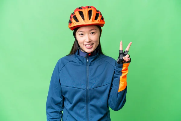 Young Cyclist Woman Isolated Chroma Key Background Smiling Showing Victory — Stockfoto