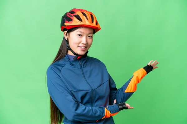 Young Cyclist Woman Isolated Chroma Key Background Extending Hands Side — Stockfoto