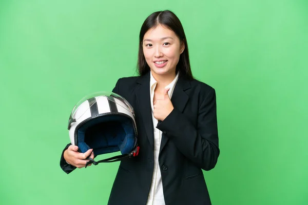 若いですアジアの女性とともにオートバイヘルメット上の隔離されたクロマキー背景与えます親指アップジェスチャー — ストック写真