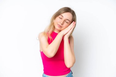 Blonde English young girl isolated on white background making sleep gesture in dorable expression