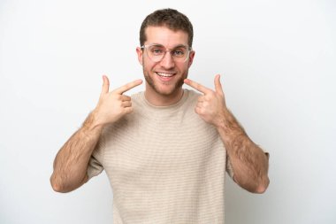 Beyaz arka planda izole edilmiş genç beyaz bir adam baş parmak hareketi yapıyor.