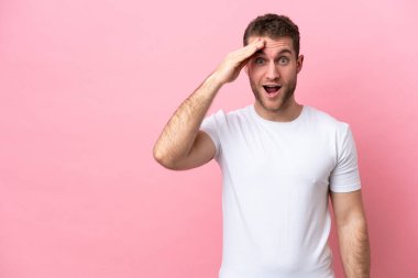 Pembe arka planda izole edilmiş genç beyaz adam bir şey fark etti ve çözüme niyetlendi.