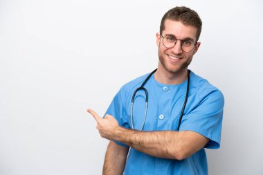 Young surgeon doctor caucasian man isolated on white background pointing back