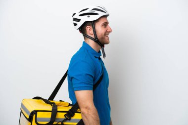 Beyaz arka planda izole edilmiş termal sırt çantalı beyaz bir adam yan yana gülüyor.