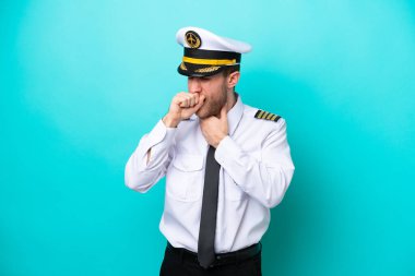 Mavi arka planda izole edilmiş beyaz uçak pilotu öksürükten muzdarip ve kötü hissediyor.
