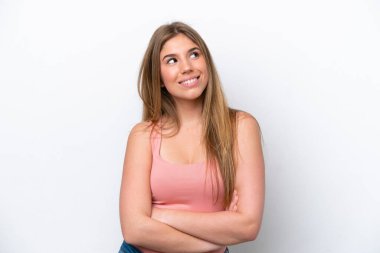 Young caucasian woman isolated on white bakcground looking up while smiling