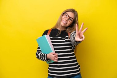 Young student woman isolated on yellow background background happy and counting three with fingers