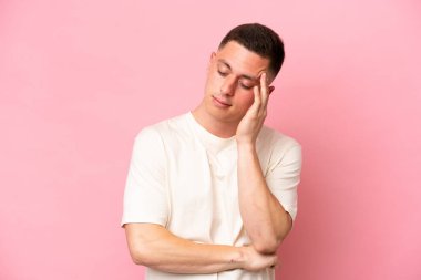Pembe arka planda başağrısı olan Brezilyalı genç bir adam.