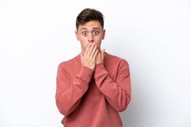 Genç ve yakışıklı Brezilyalı bir adam beyaz arka planda izole edilmiş, ağzı elleriyle kapatıyor.