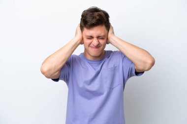 Beyaz arka planda izole edilmiş yakışıklı Brezilyalı adam hayal kırıklığına uğramış ve kulaklarını kapatmış.