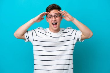 Young handsome Brazilian man isolated on blue background with surprise expression
