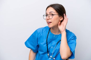 surgeon doctor woman holding tools isolated on white background listening to something by putting hand on the ear
