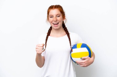Young caucasian reddish woman playing volleyball isolated on white background celebrating a victory in winner position