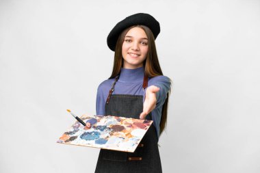 Young artist man holding a palette over isolated white background shaking hands for closing a good deal