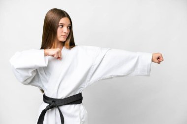 Teenager girl over isolated white background doing karate