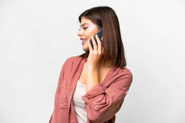 Young Russian woman over isolated white background keeping a conversation with the mobile phone with someone
