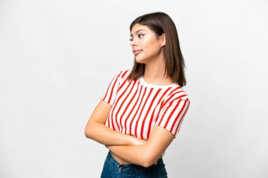 İzole edilmiş beyaz arka planda genç bir Rus kadın omuzlarını kaldırırken şüphe jesti yapıyor.