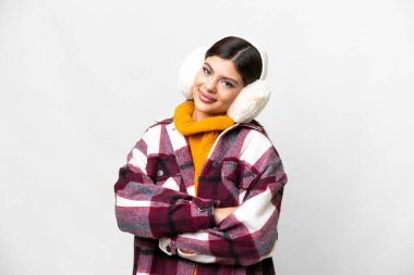Young Russian woman wearing winter muffs over isolated white background keeping the arms crossed in frontal position