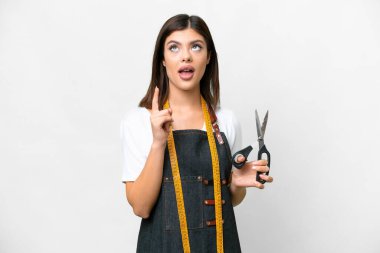 Seamstress woman over isolated white background thinking an idea pointing the finger up