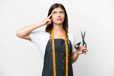 Seamstress woman over isolated white background having doubts and thinking