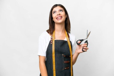 Seamstress woman over isolated white background laughing