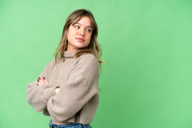 Kolları çapraz ve mutlu bir şekilde izole edilmiş krom anahtar geçmişi olan genç bir kız.