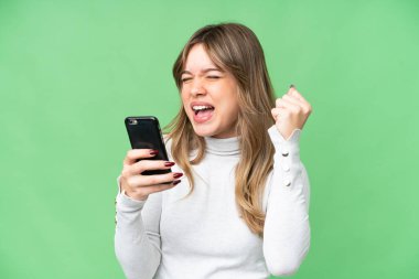 Cep telefonu kullanarak ve zafer jesti yaparak izole edilmiş krom anahtar geçmişi olan genç bir kız.