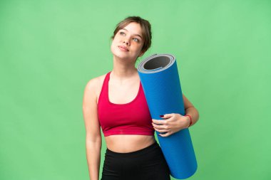 Genç sporcu kız yoga derslerine giderken elinde bir paspas tutarak izole edilmiş krom anahtar arkaplanı araştırırken aklına bir fikir geldi.